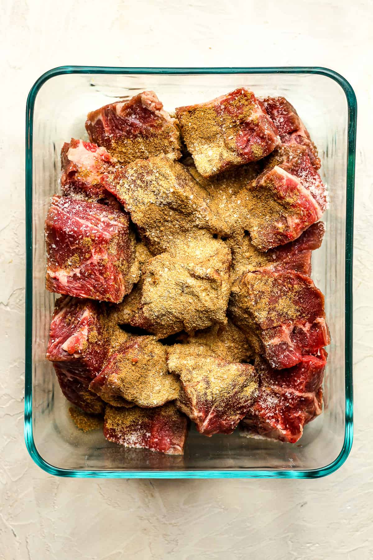 A bowl of the chunks of beef with seasonings.