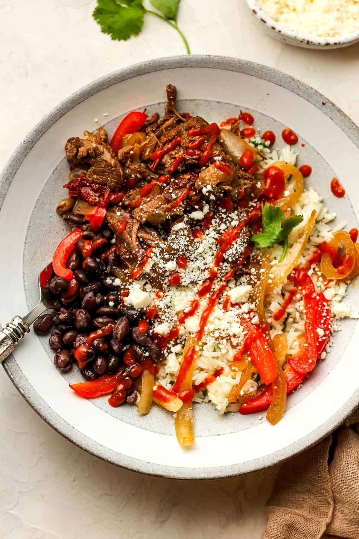 A shredded beef chipotle bowl with beans and rice.