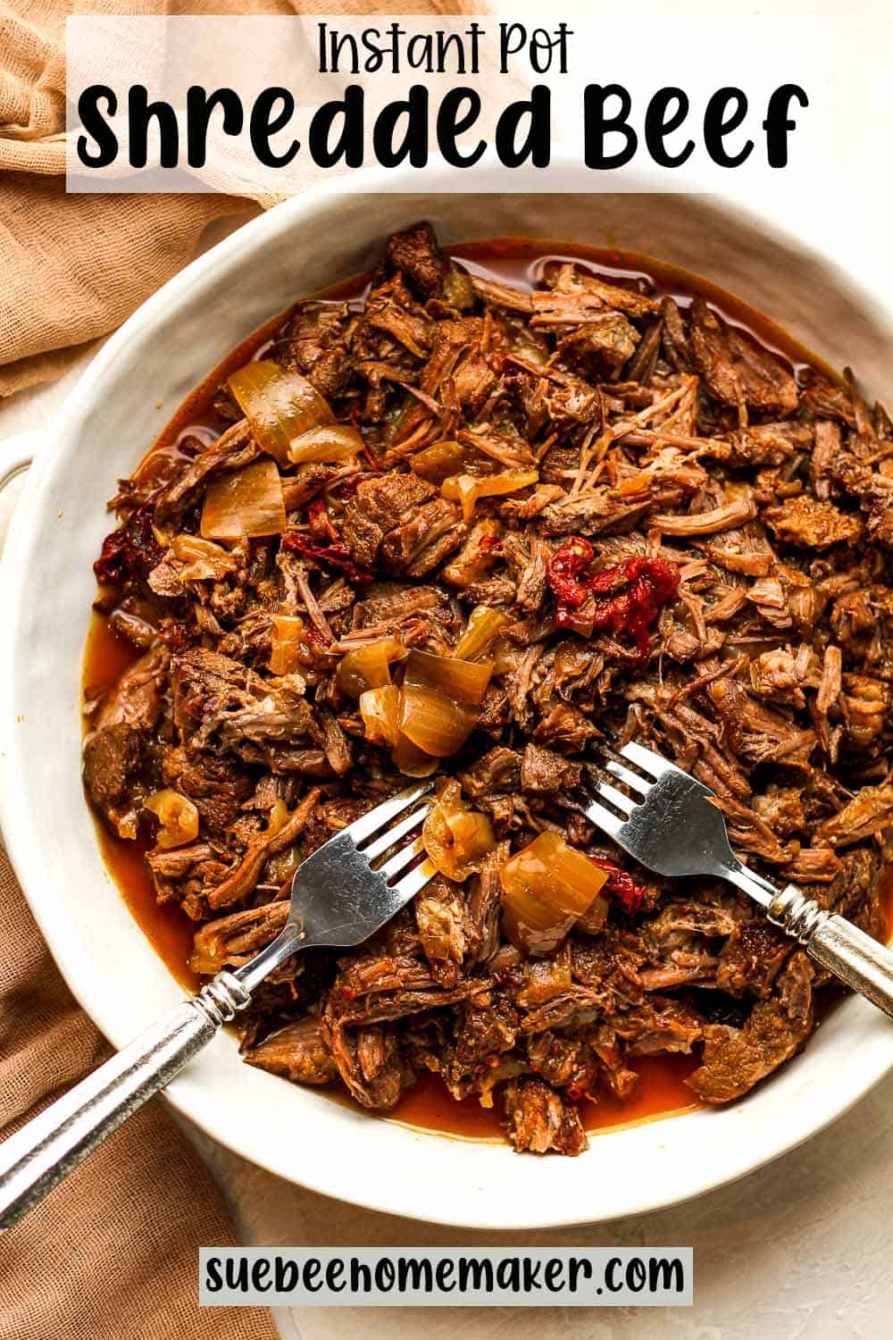 A round dish of instant pot shredded beef with two forks.