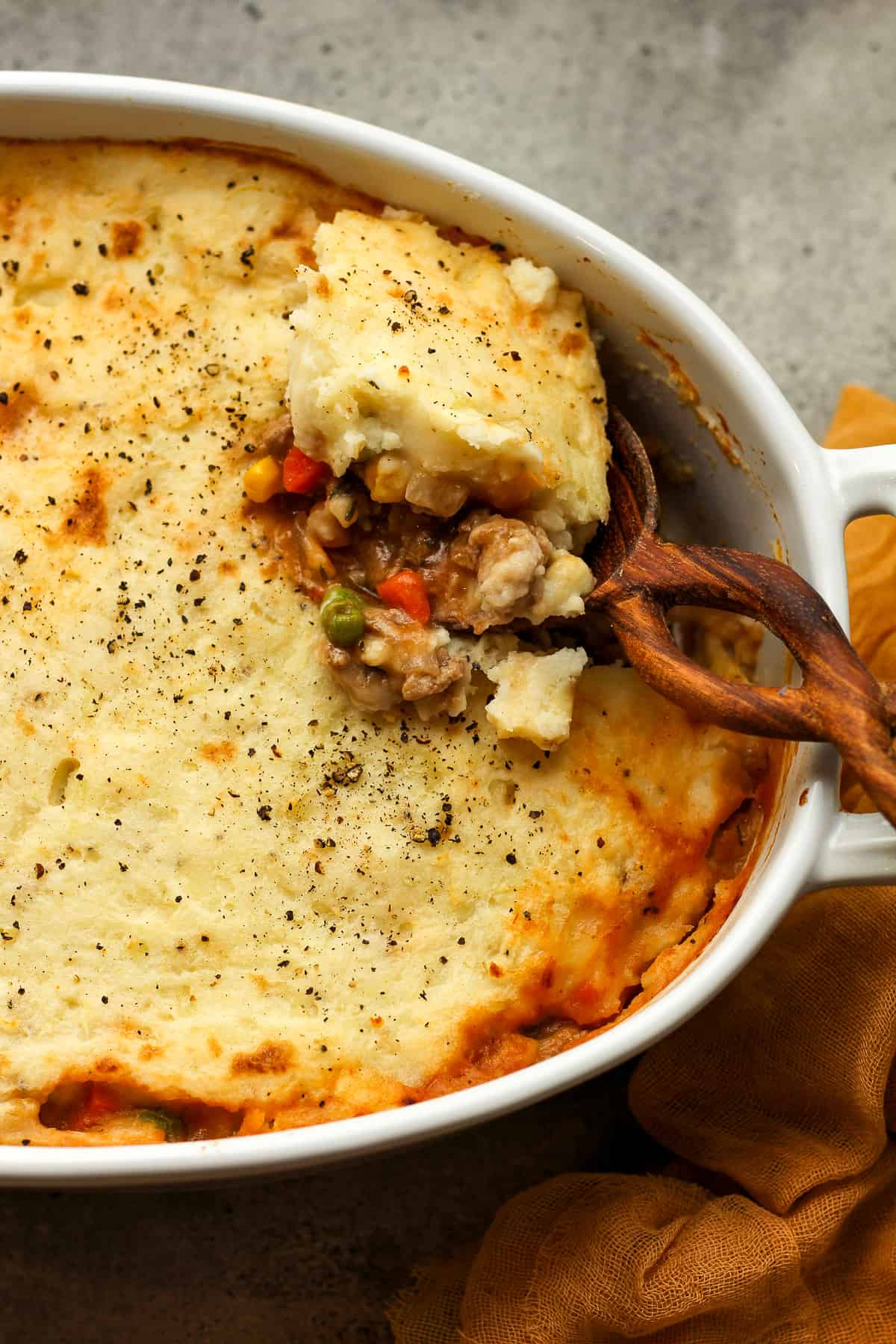 A wooden spoon with some shepherd's pie.
