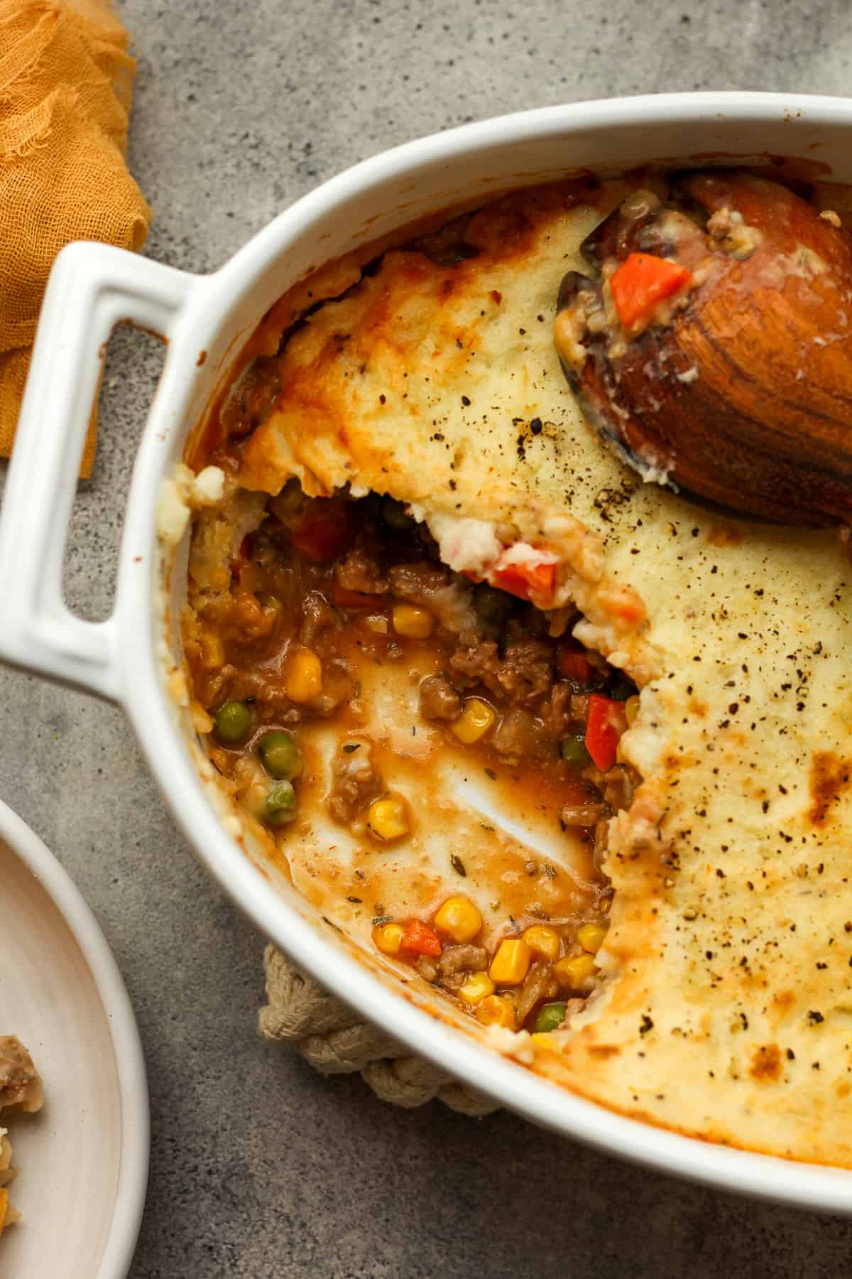 A closeup on the shepherds pie with a serving removed.