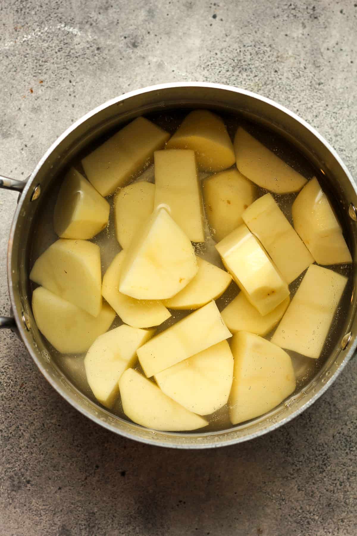 A pot of the potato chunks in water.