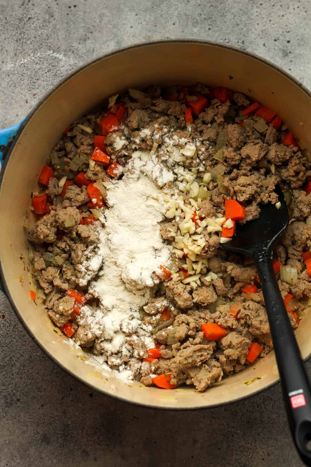 A pot of the brown meat with flour on top.
