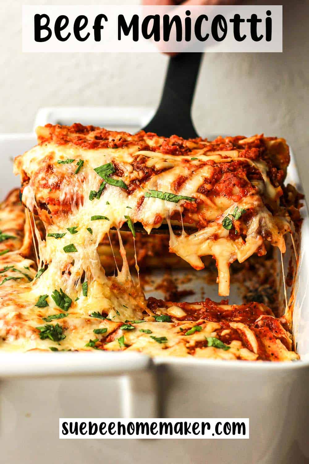 Closeup on a serving of beef manicotti over a casserole dish.