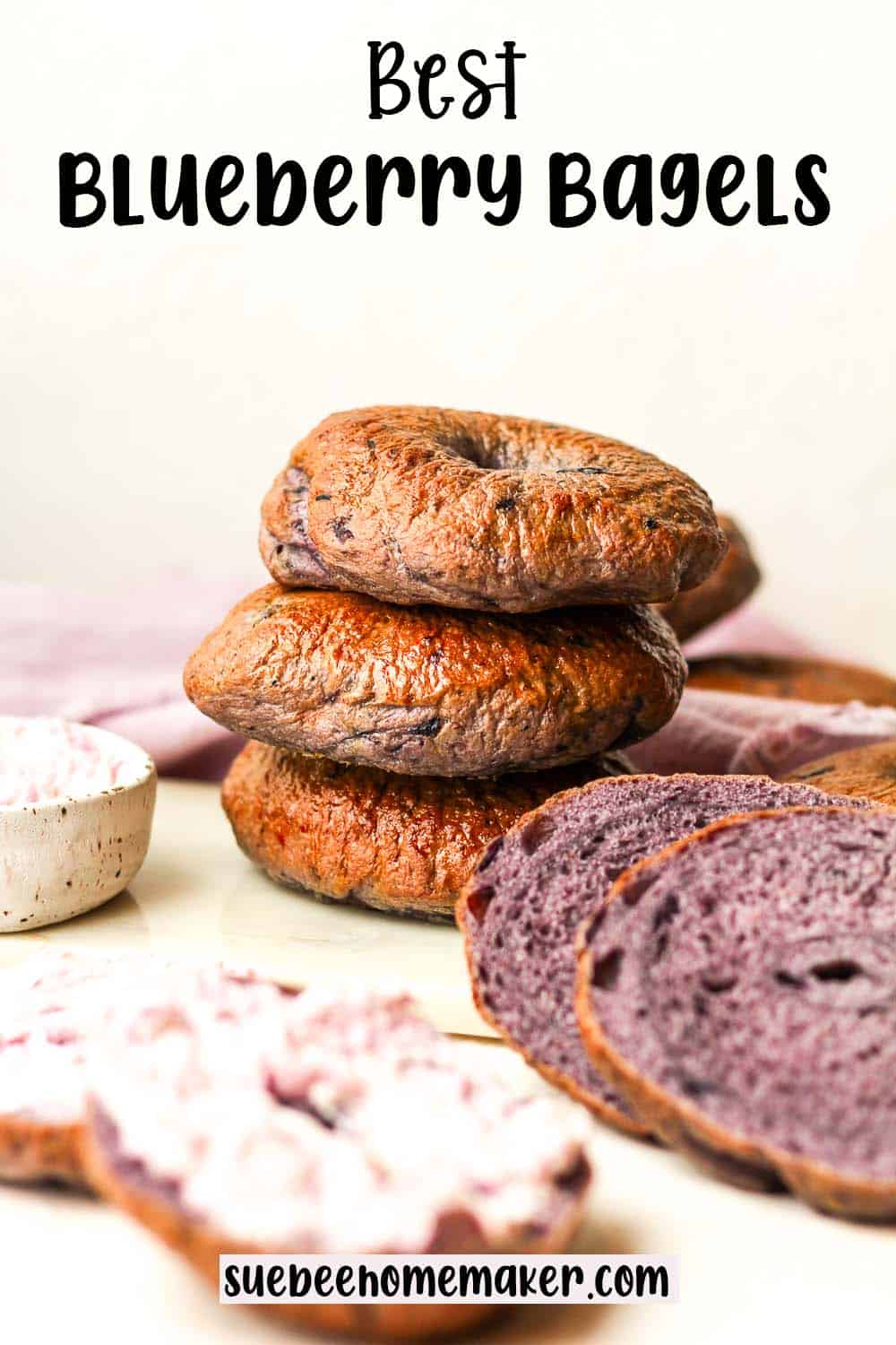 Three stacked blueberry bagels.