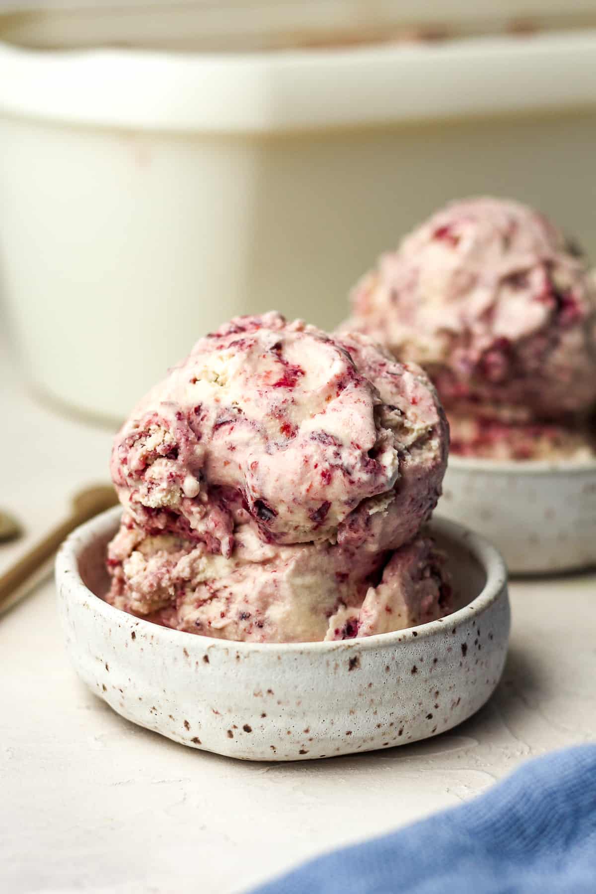 Side view of two small bowls of cherry ice cream.