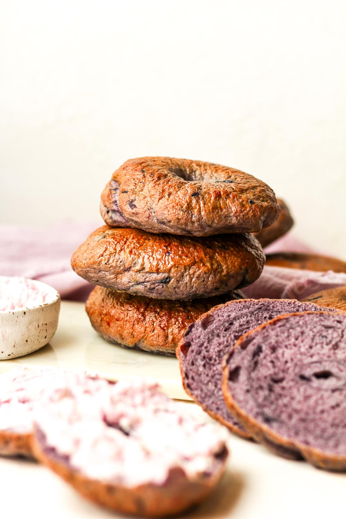 Side view of three stacked blueberry bagels.