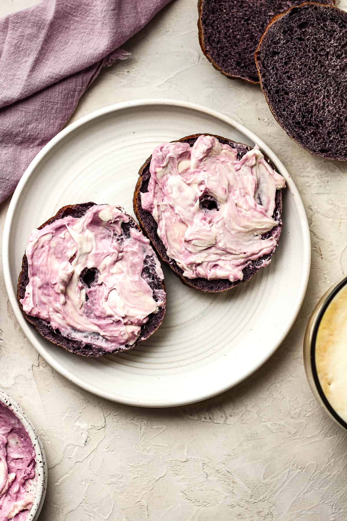 A sliced blueberry bagel with cream cheese.