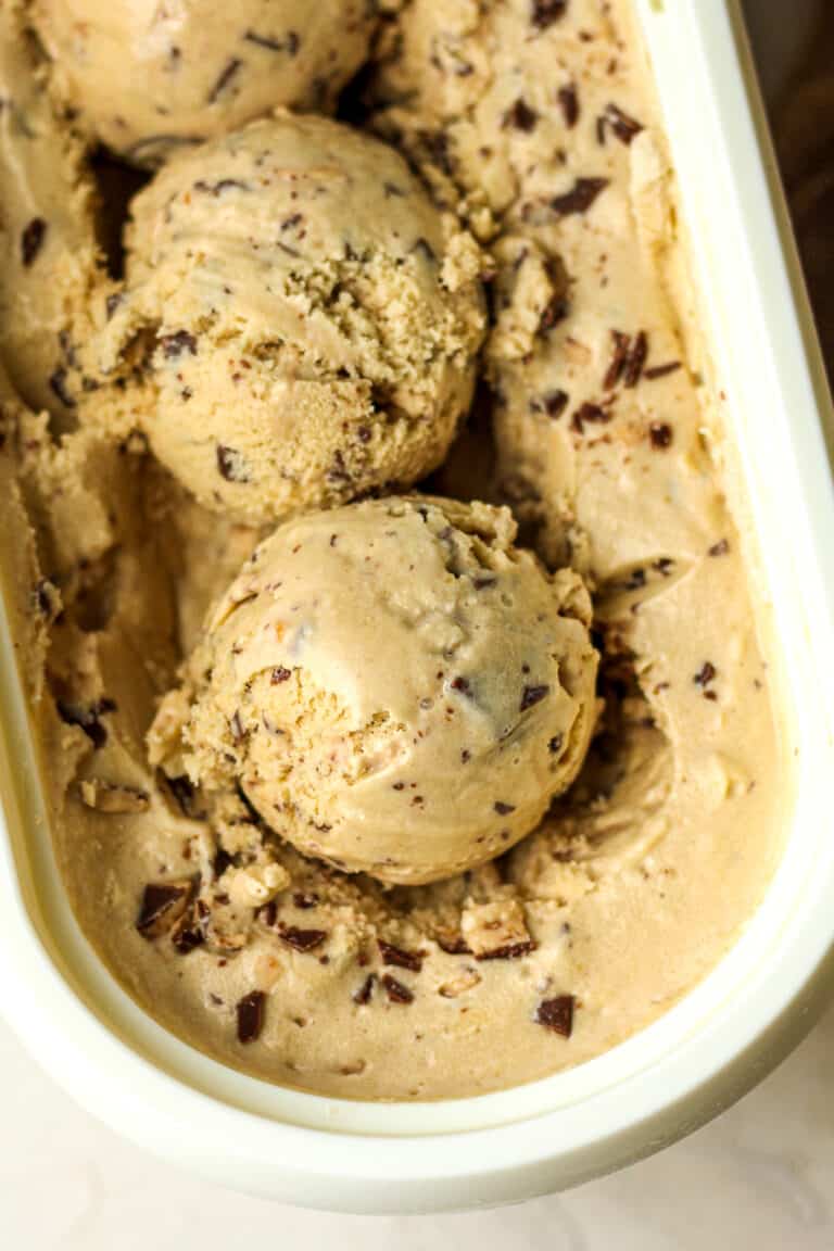 Closeup on two dips of coffee toffee ice cream in a container.