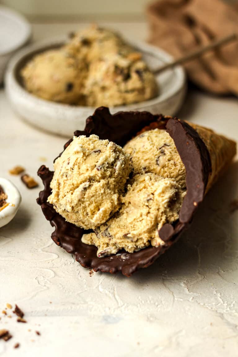 Side view of a waffle cone with three dips of coffee toffee ice cream.