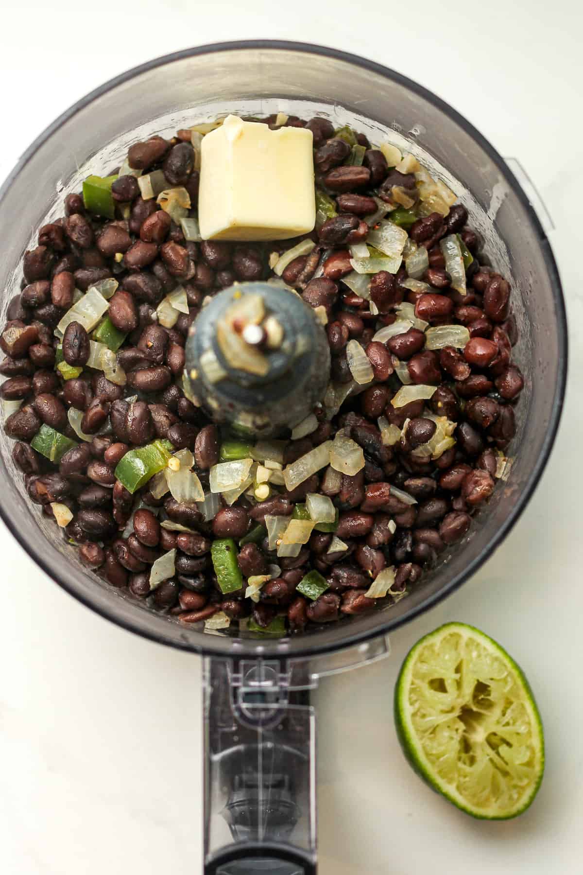 A food processor of the black bean mixture with the butter on top.