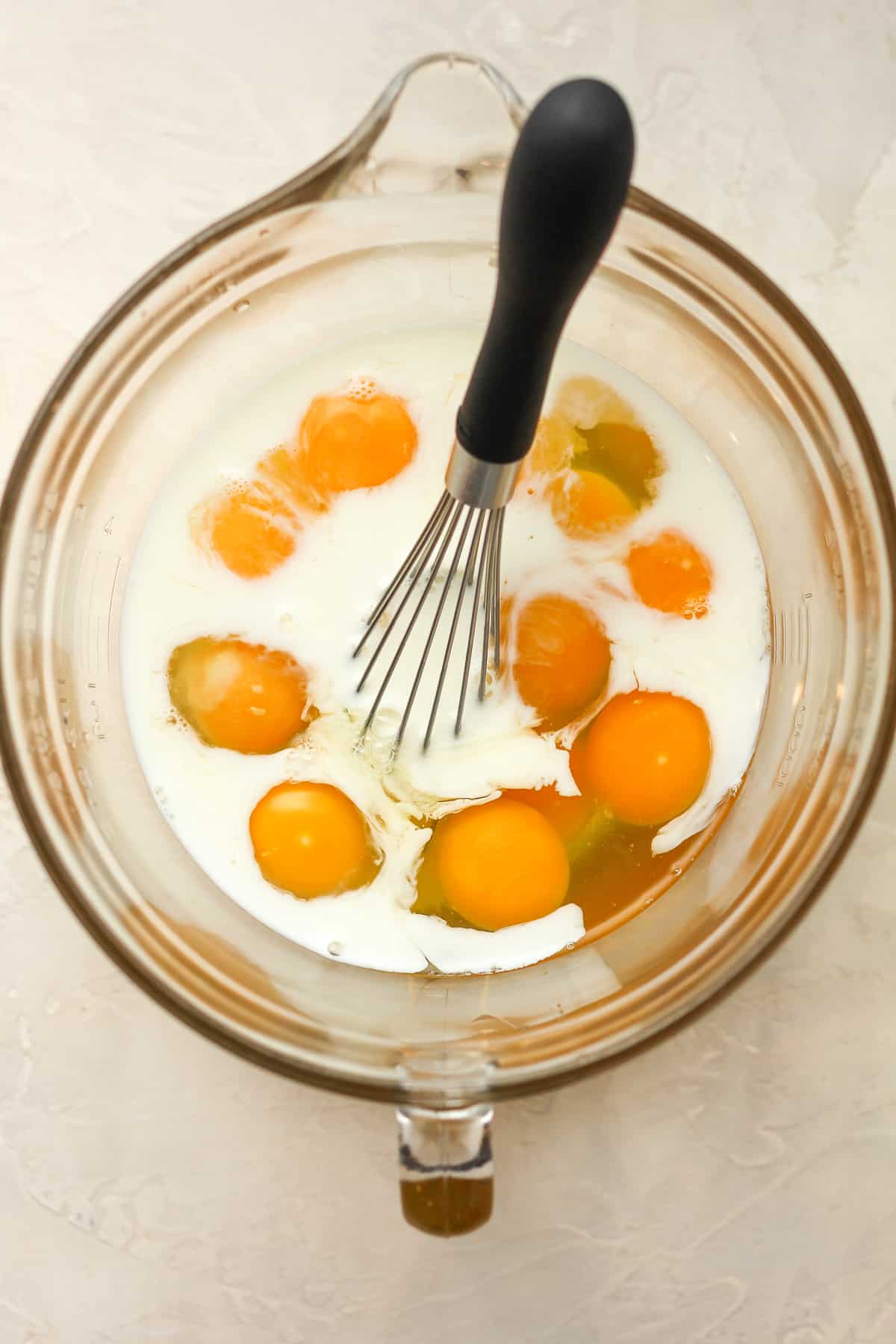 A large measuring cup with the eggs and milk.