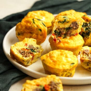 A plate of sausage and egg muffins with veggies.