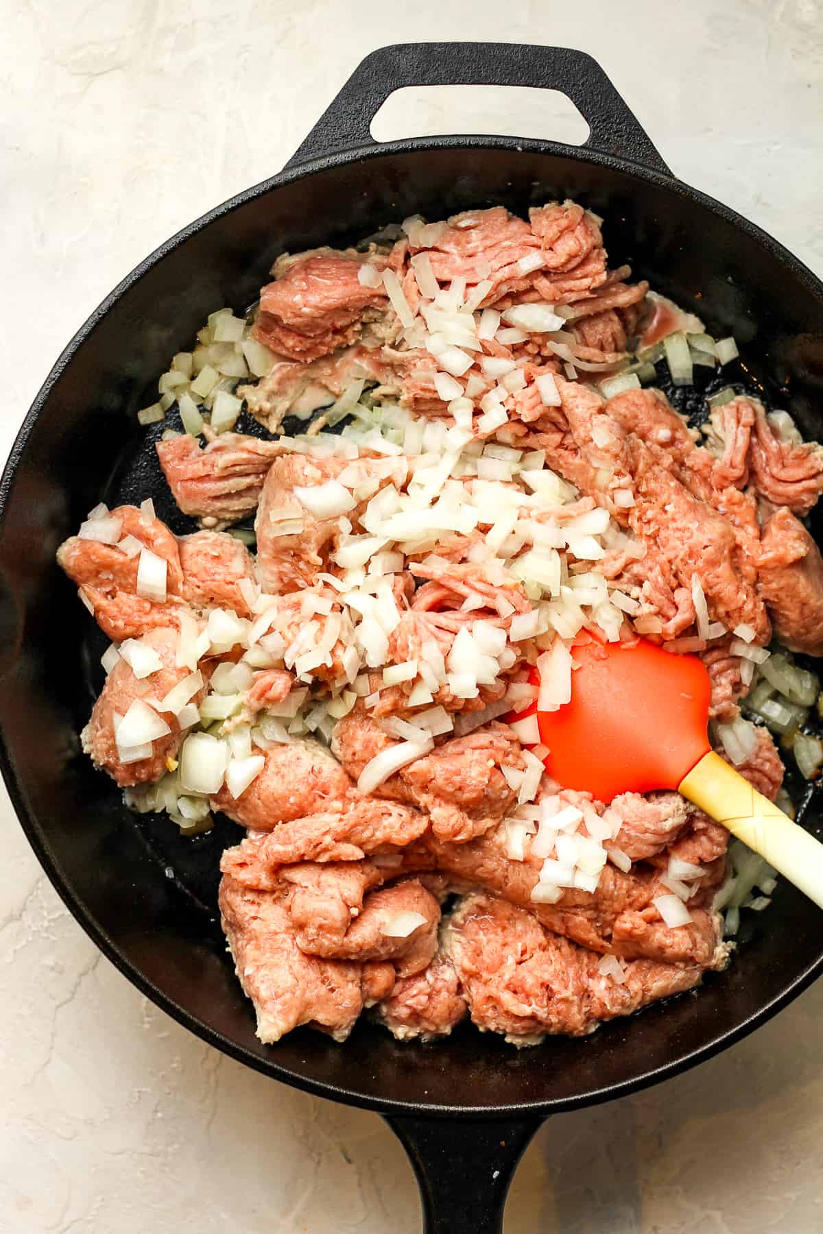 A skillet of the raw ground turkey and onions.