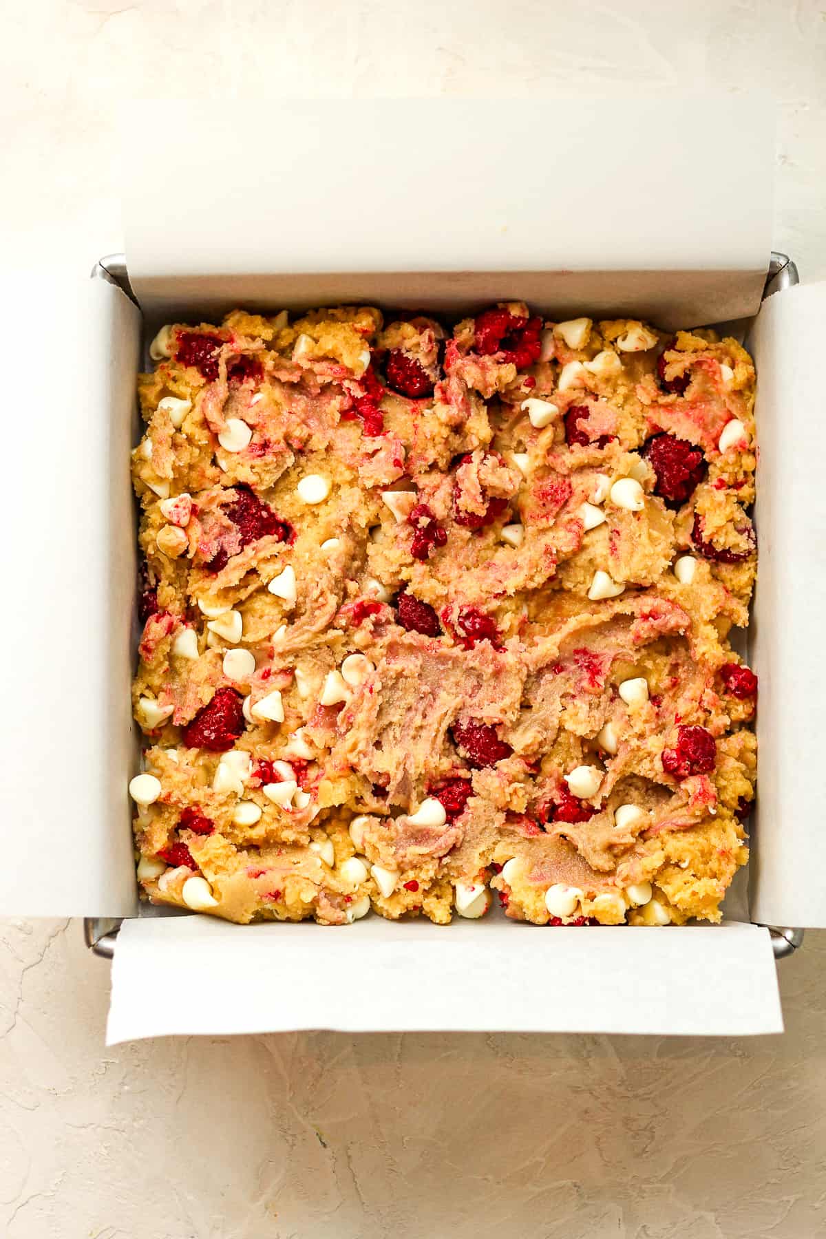 A square pan of white chocolate and raspberry blondies.