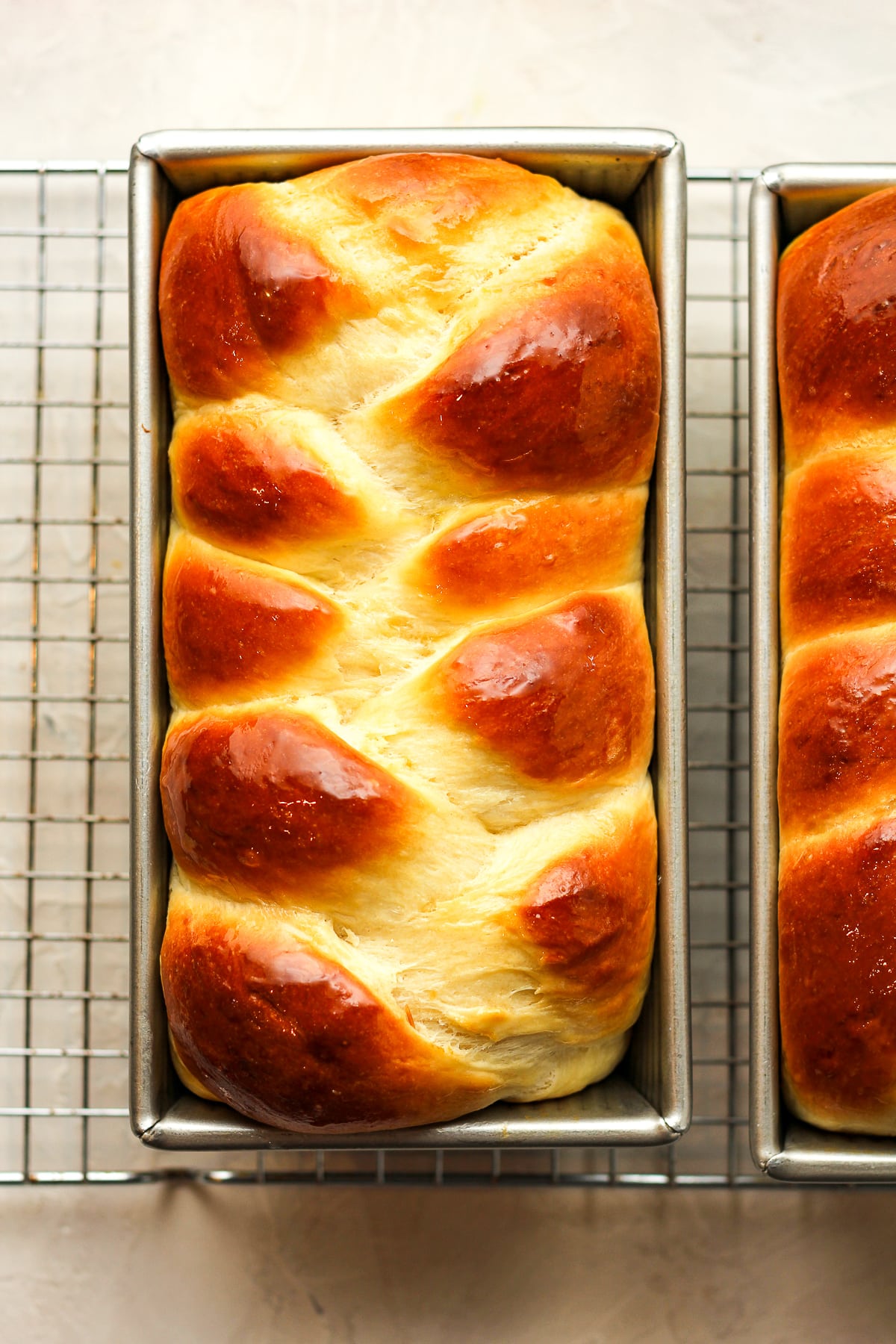 Two loaves of baked brioche bread - braided.