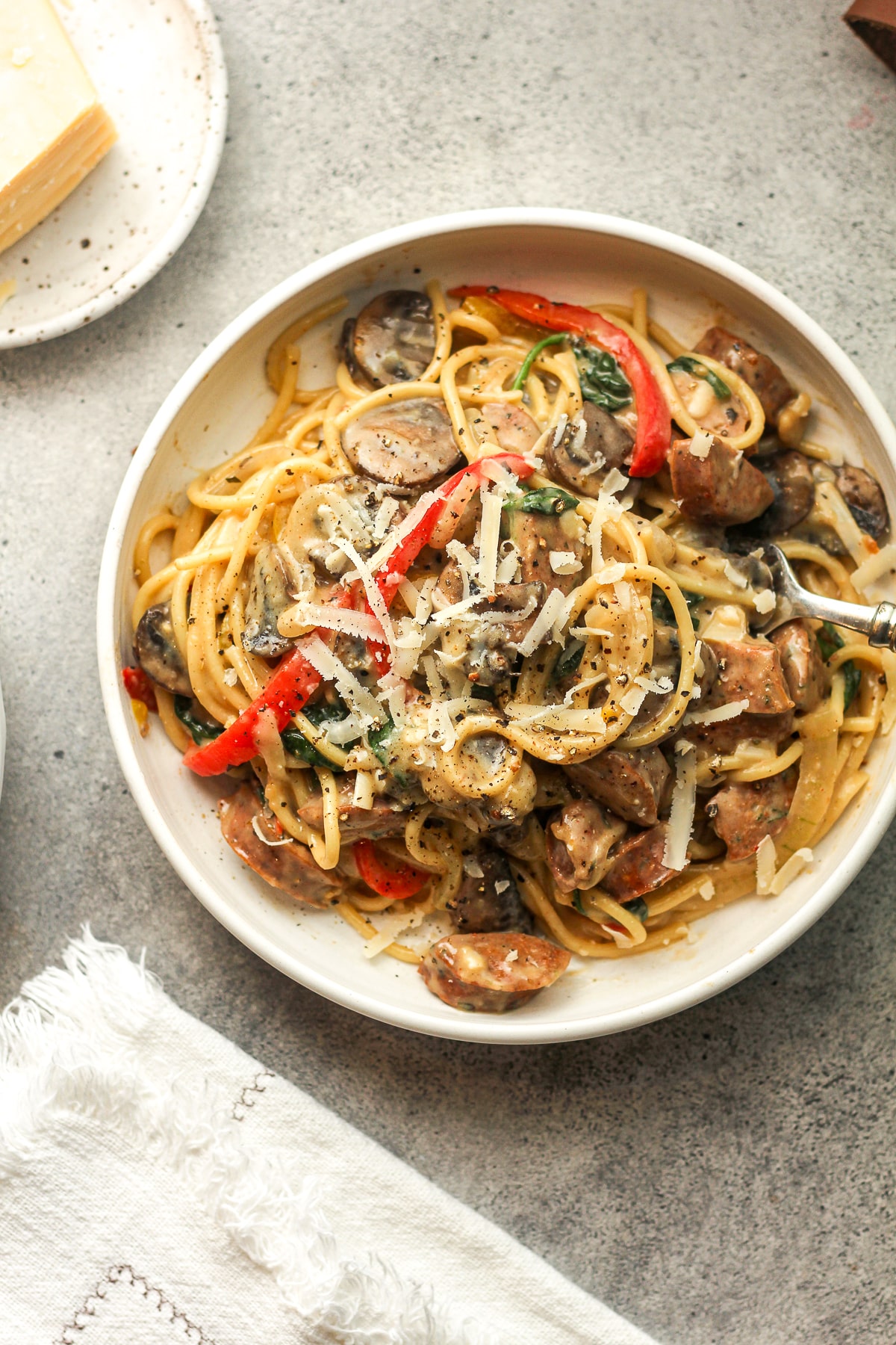 A bowl of cajun chicken sausage pasta with peppers and mushrooms.
