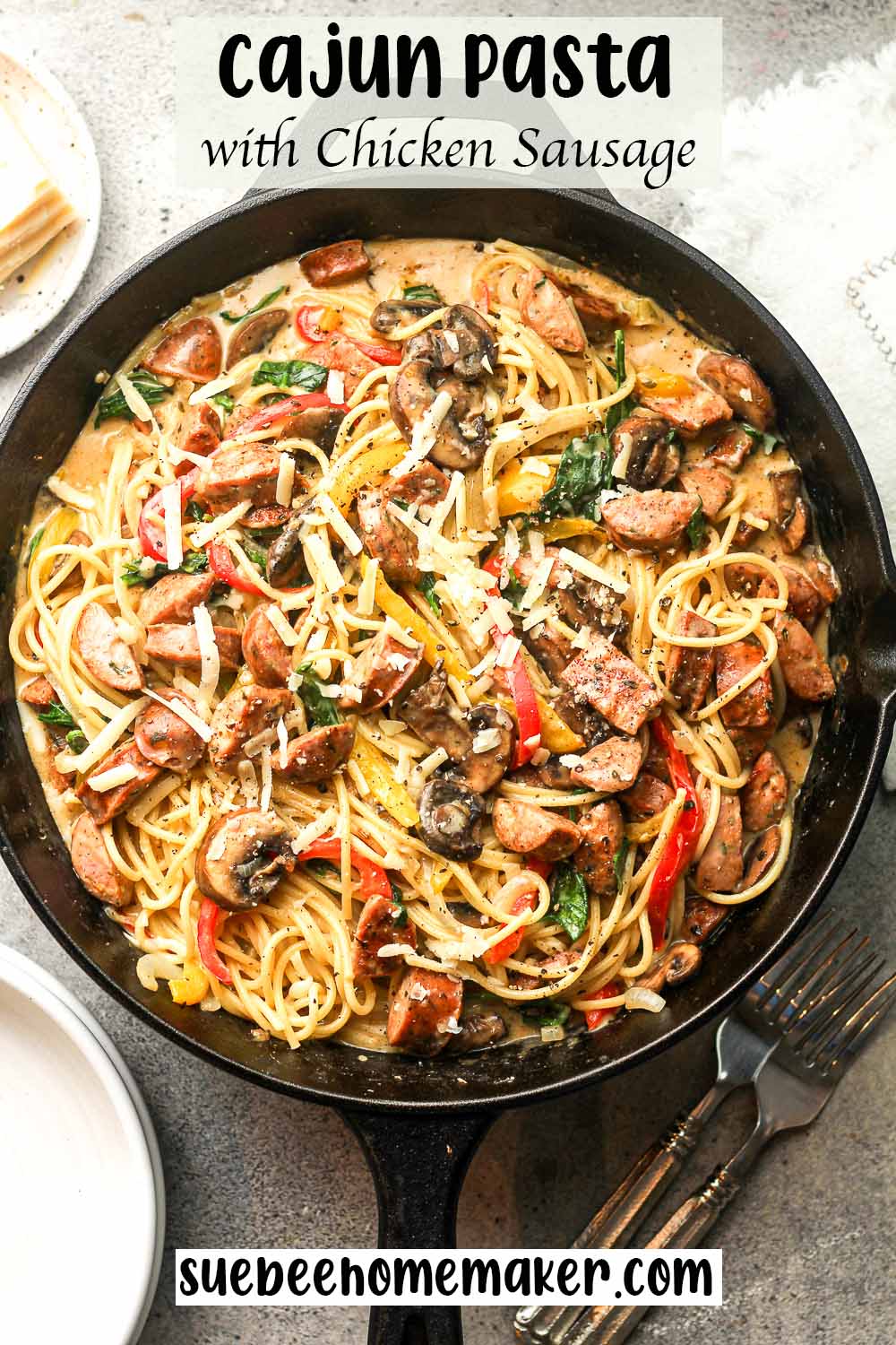 A large skillet of cajun pasta with chicken sausage.