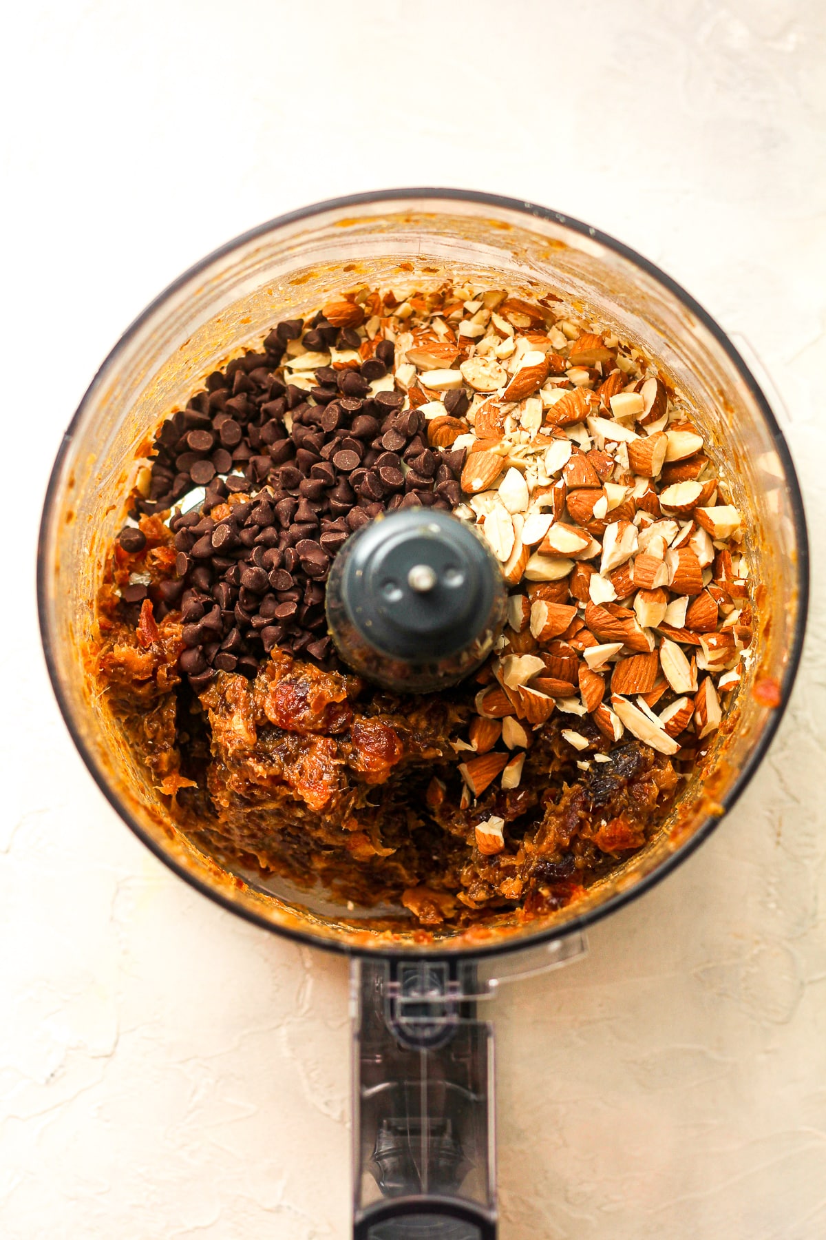 A food processor of the dates, almonds, and chocolate chips.