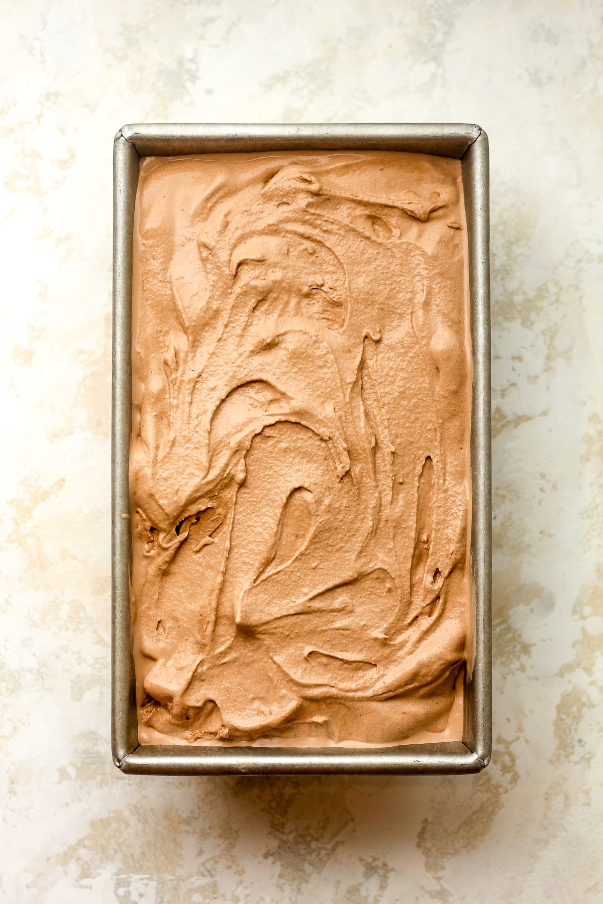A rectangular pan of creamy chocolate ice cream.