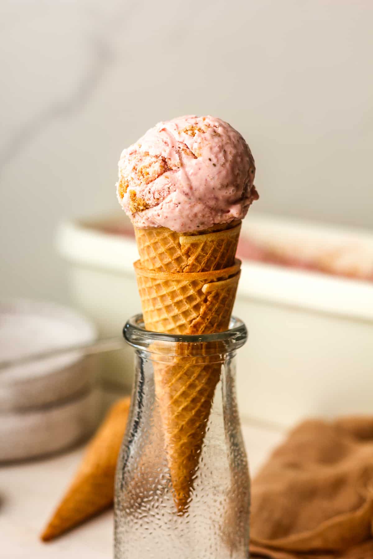 Side view of a sugar cone with a scoop of ice cream on top.