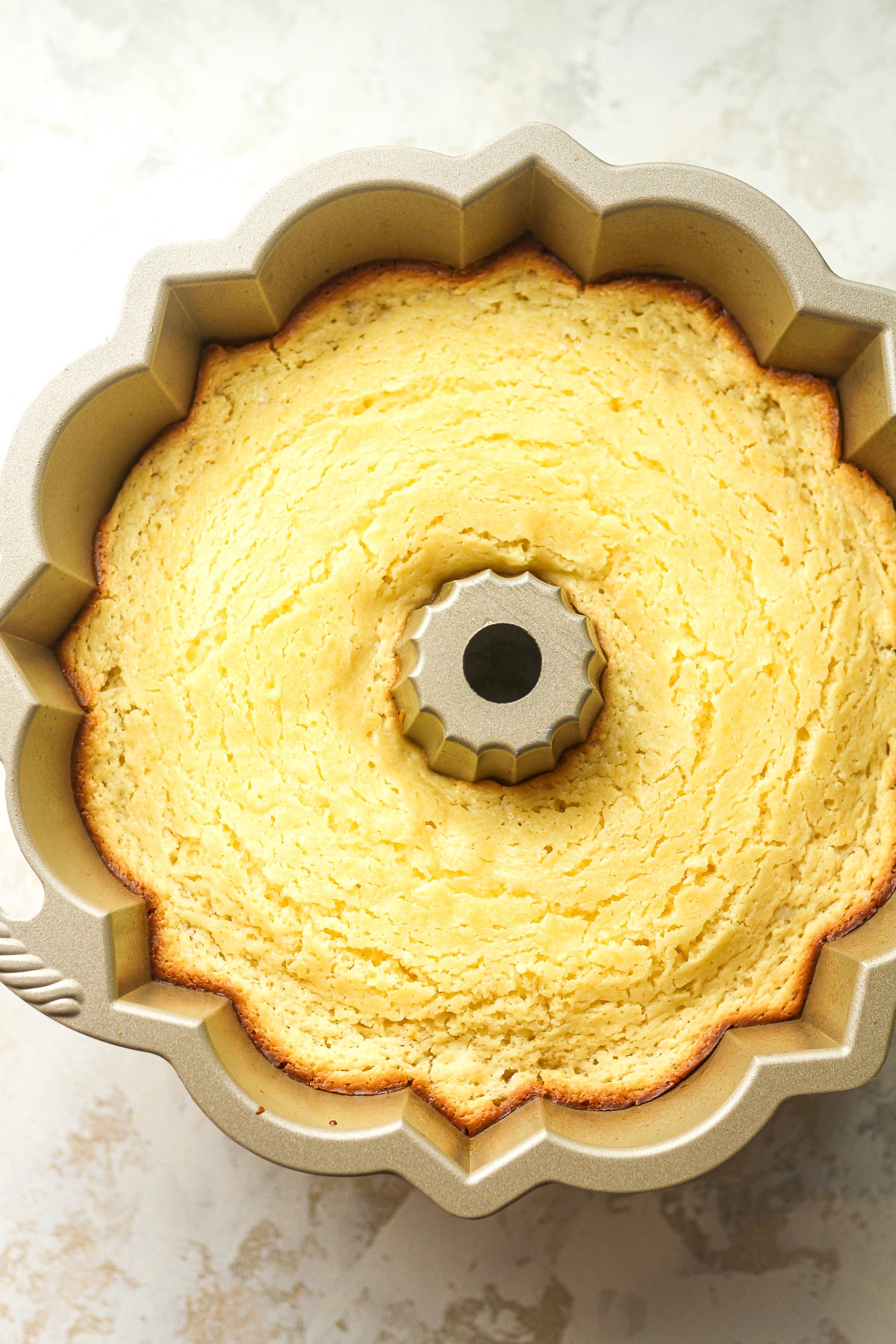 The just baked lemon bundt cake in a bundt pan.