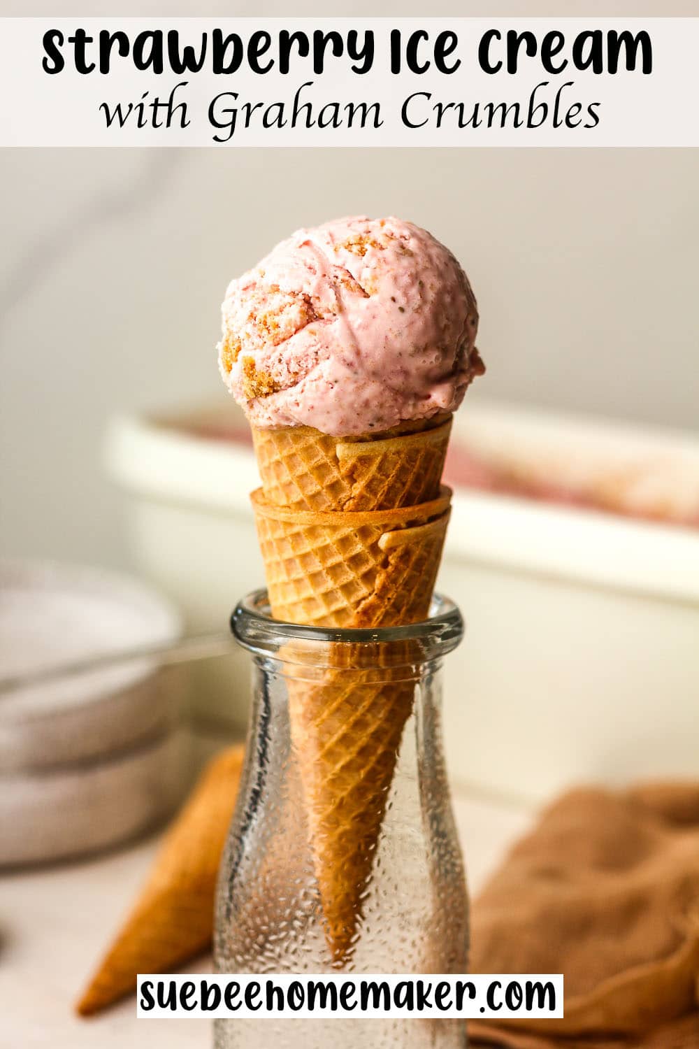 Side view of a strawberry ice cream cone with graham crumbles.
