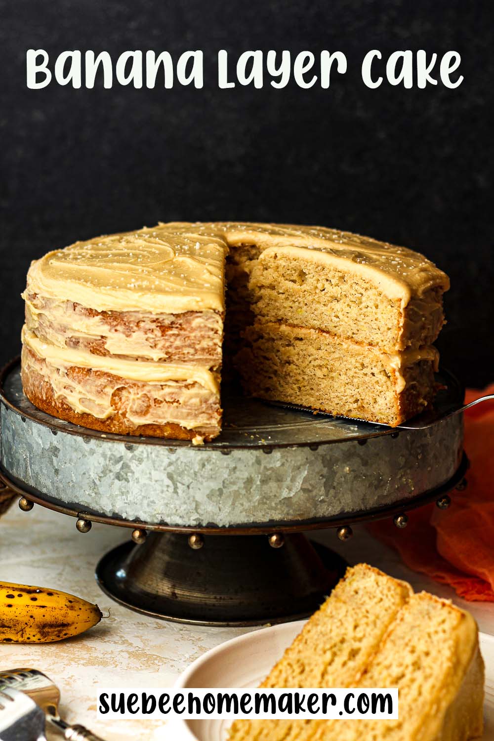 Side view of a banana layer cake on a silver cake stand.