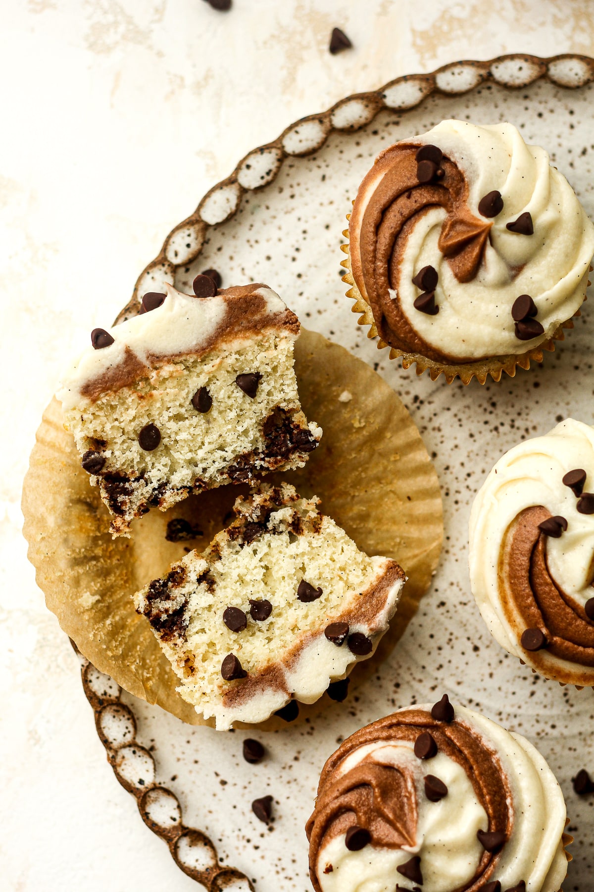 Overhead view of a plate of chocolate chip cupcakes with swirl buttercream.