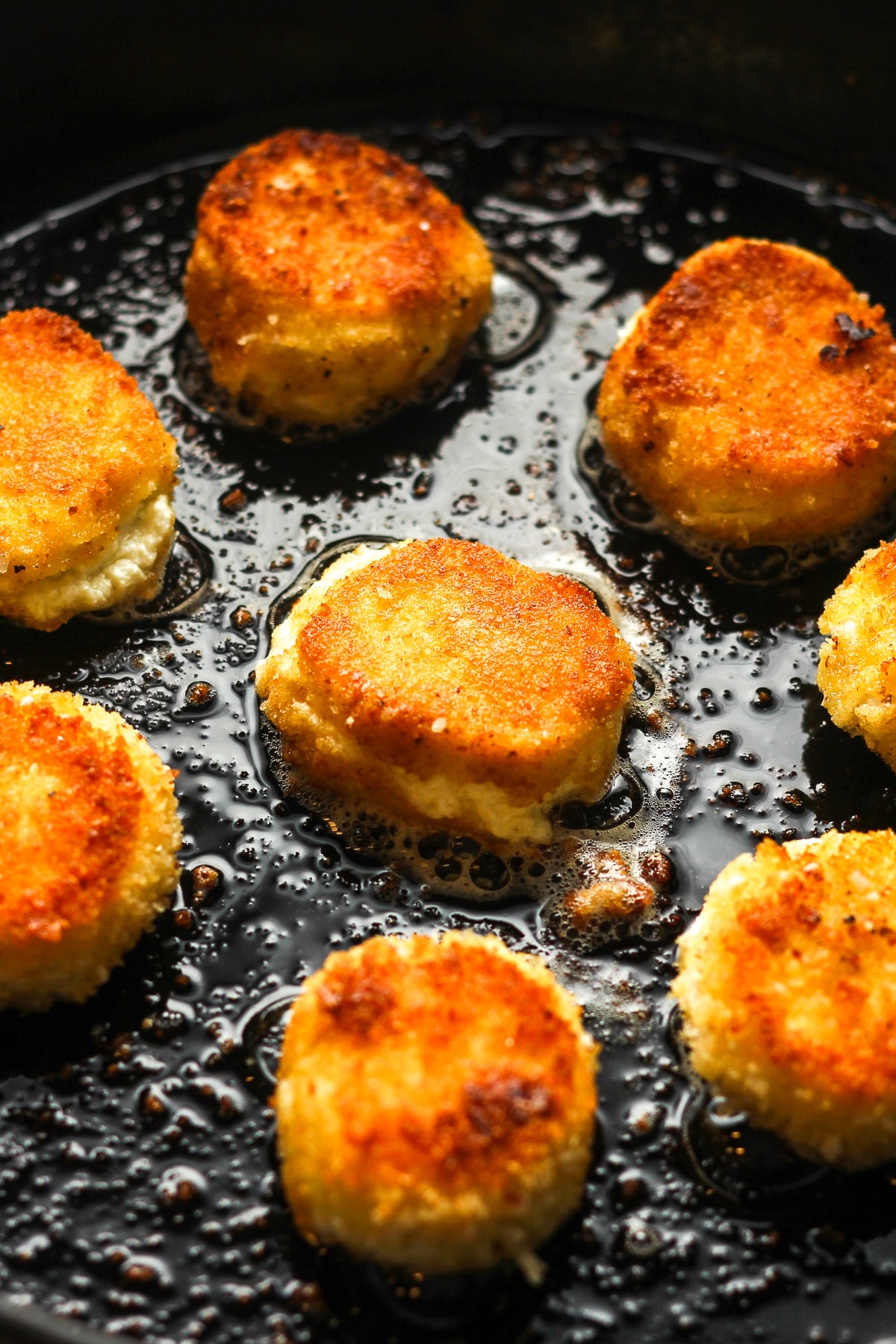 Closeup on a cast iron skillet of our fried goat cheese.