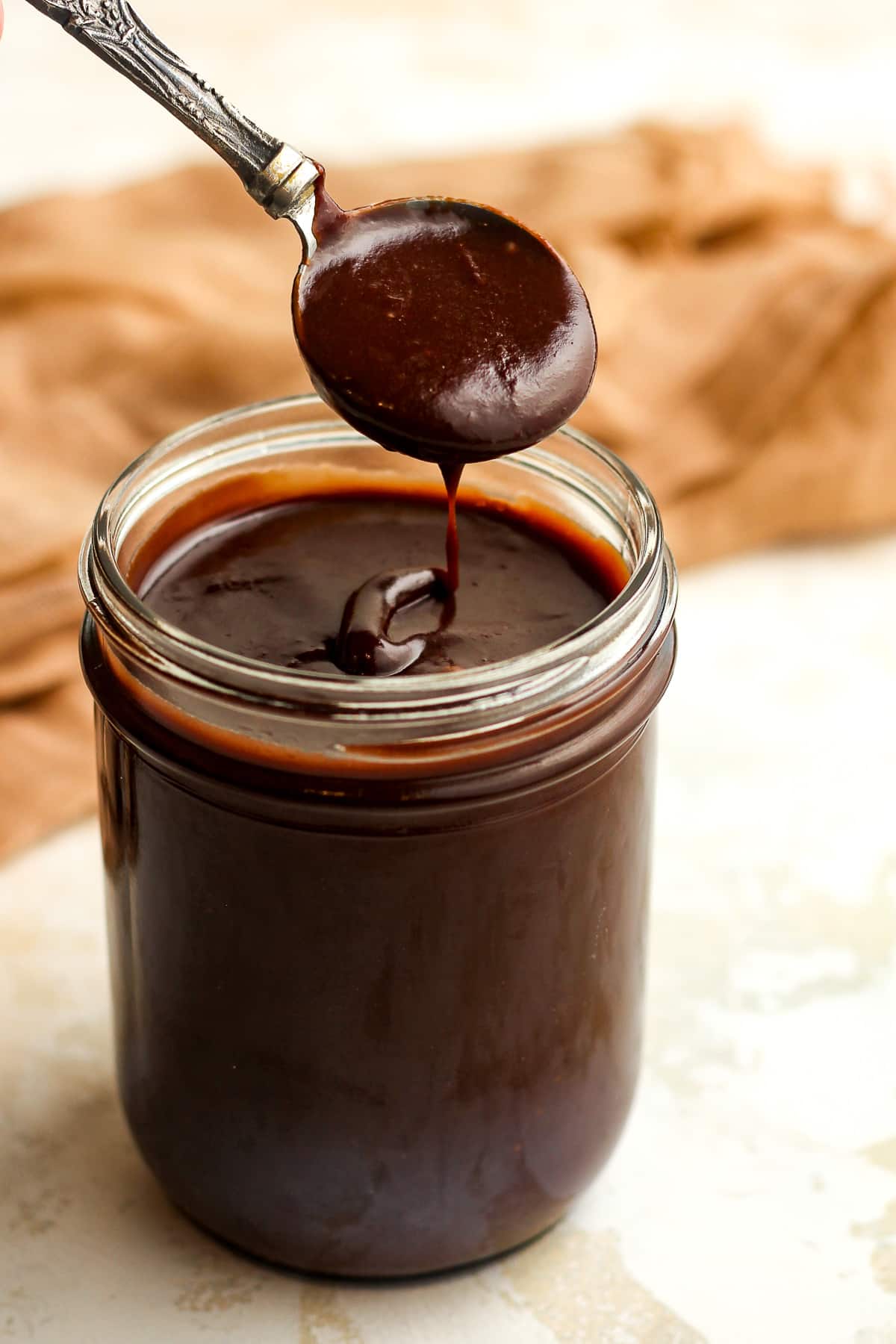 Side view of a jar of hot fudge sauce.