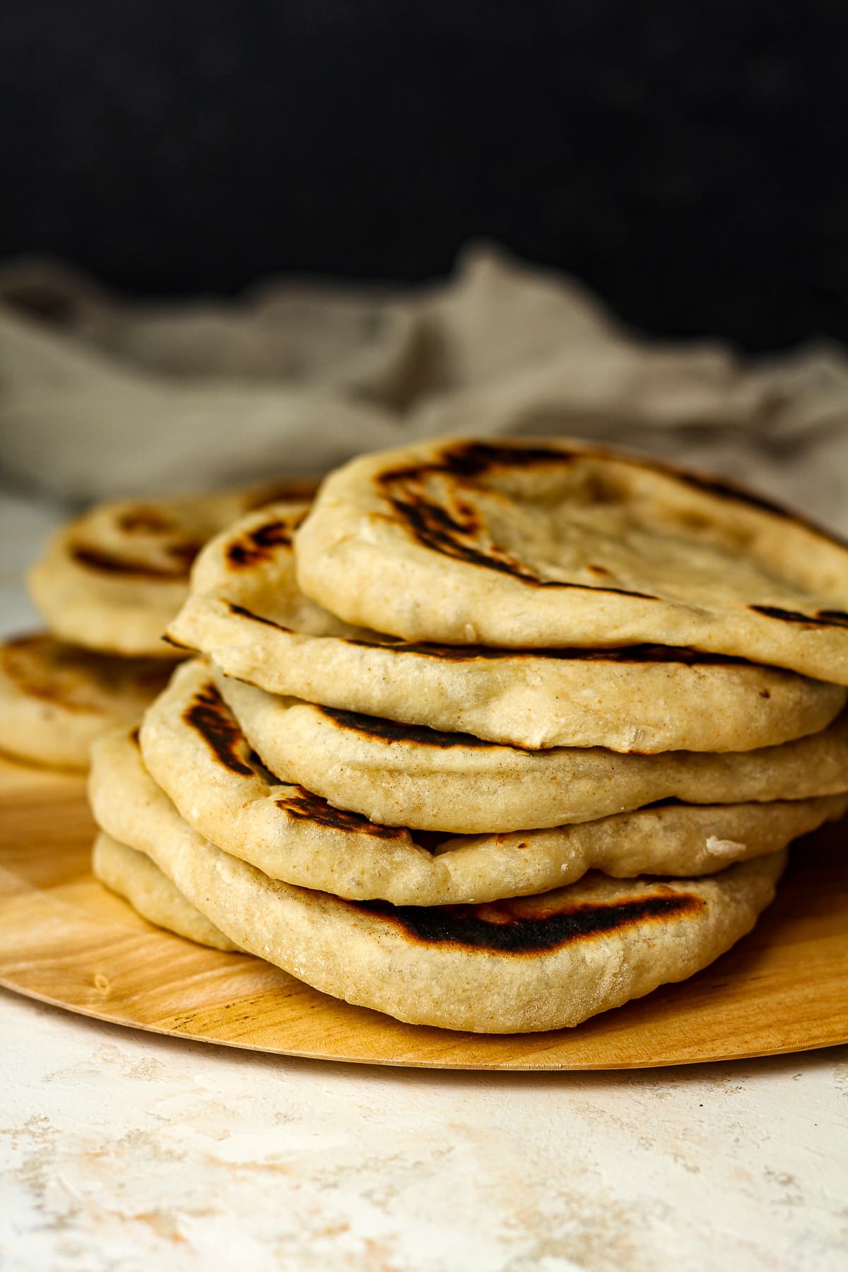 A stack of sourdough naan showing the pillowy centers.
