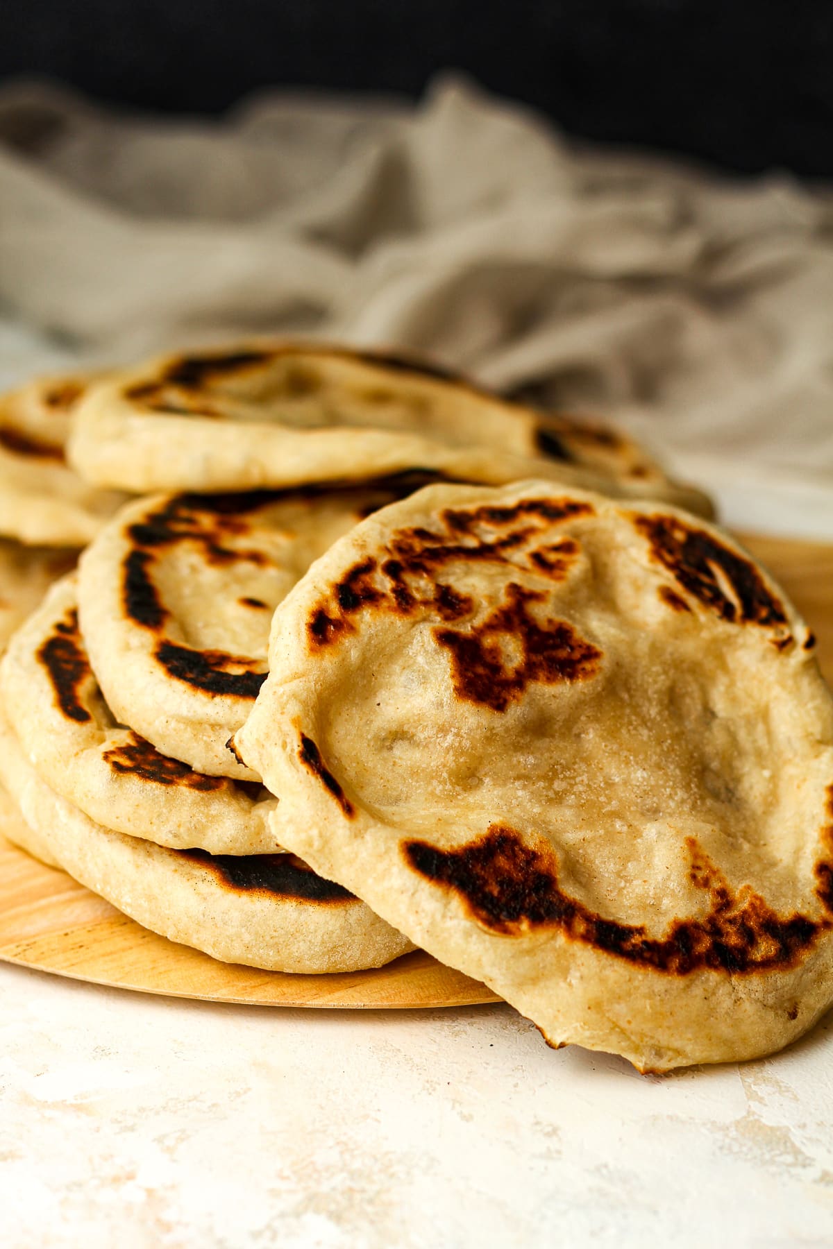 Side view of several pieces of sourdough naan with browned edges.