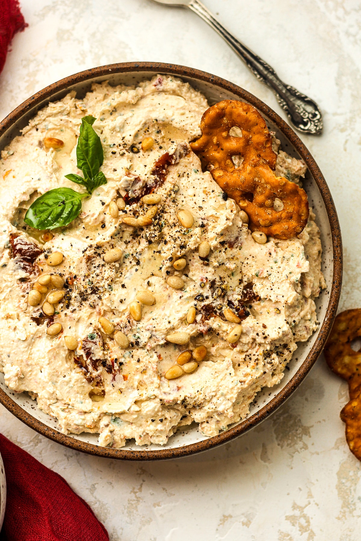 Overhead view of a bowl of cream cheese dip with sun-dried tomatoes.