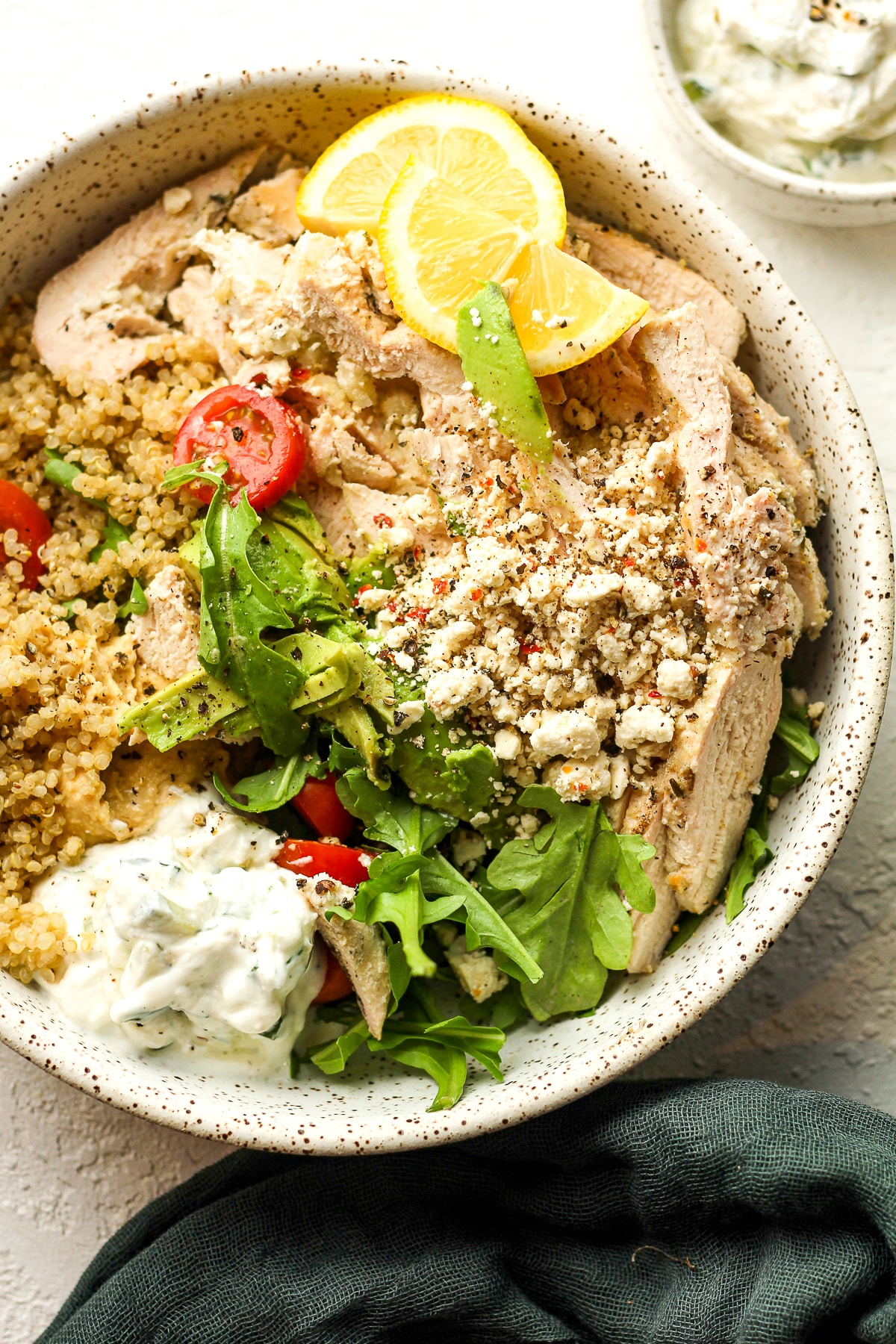 Closeup on a grain bowl with Greek chicken and tzatziki.