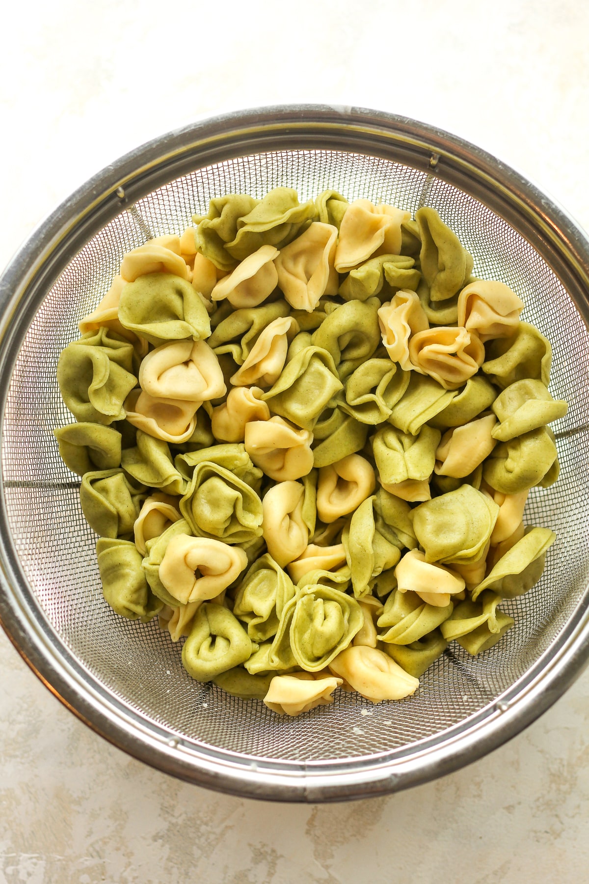 A colander of the cooked tortellini pasta.