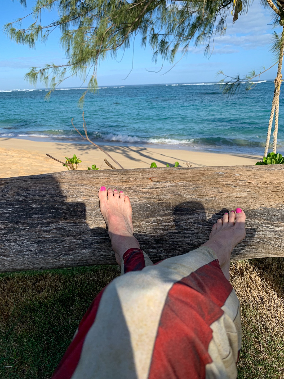 My feet resting on a log by the ocean.