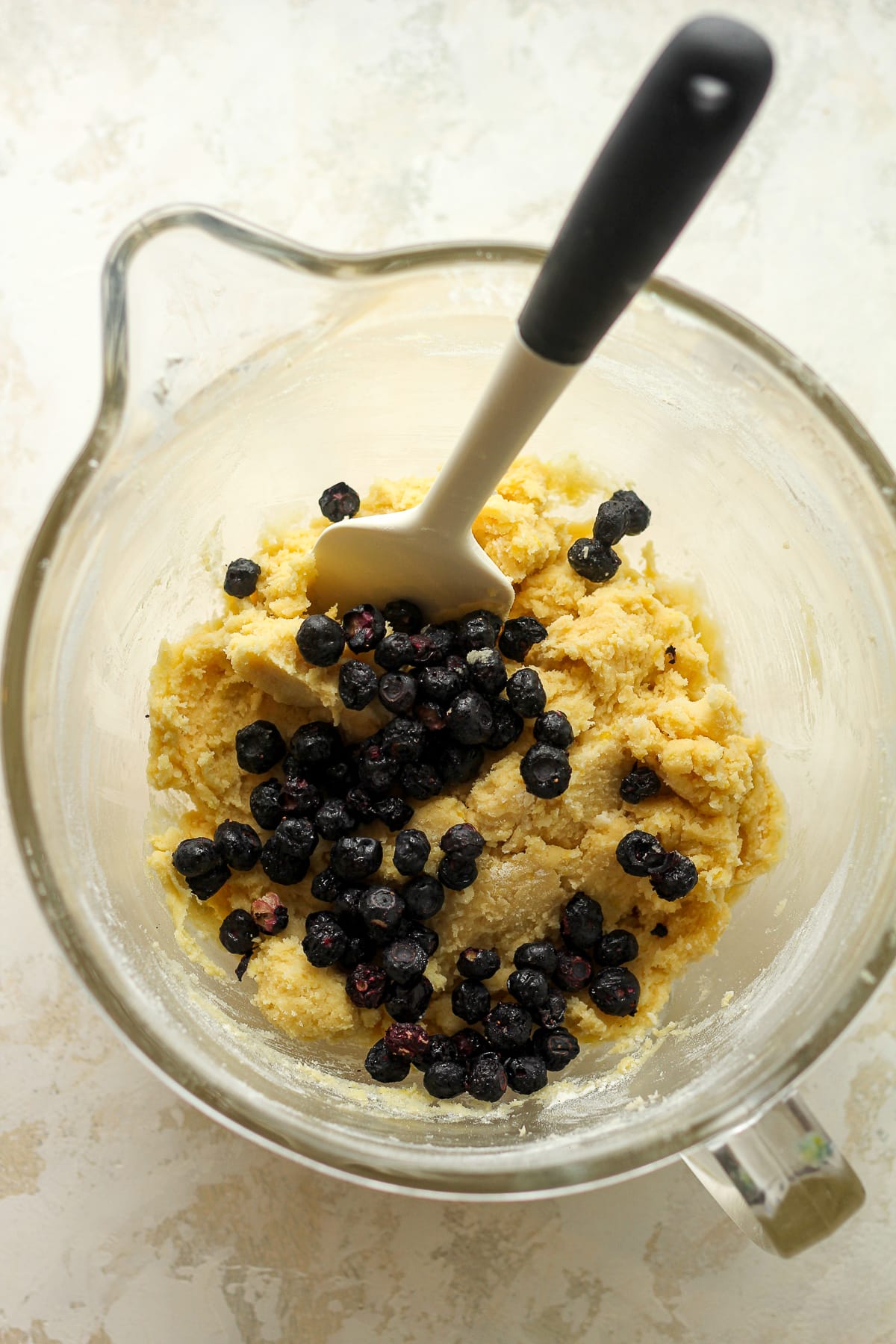 A mixing bowl of the cookie batter with the freeze-dried blueberries on top.