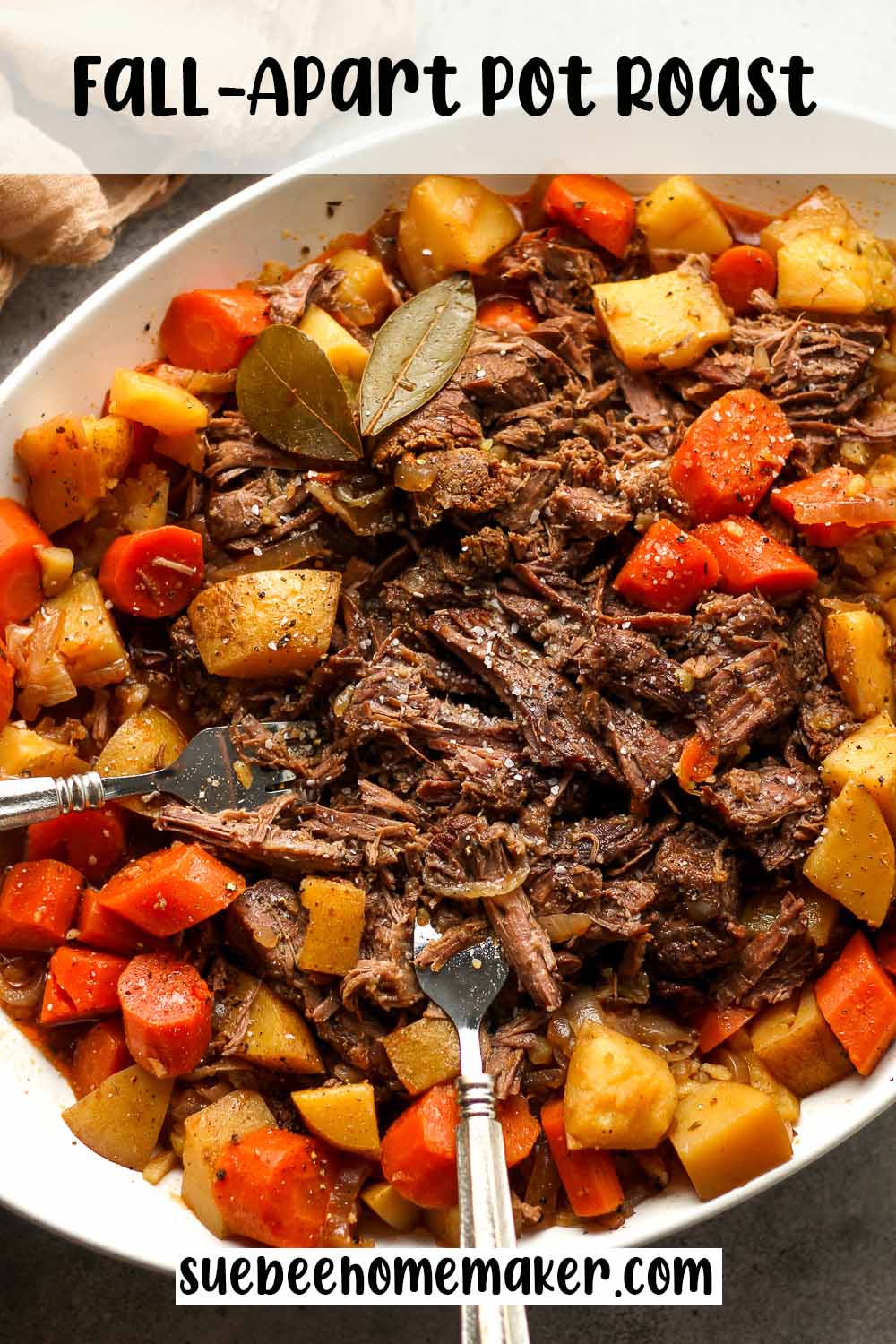 An oblong dish with a fall-apart pot roast with potatoes and carrots.
