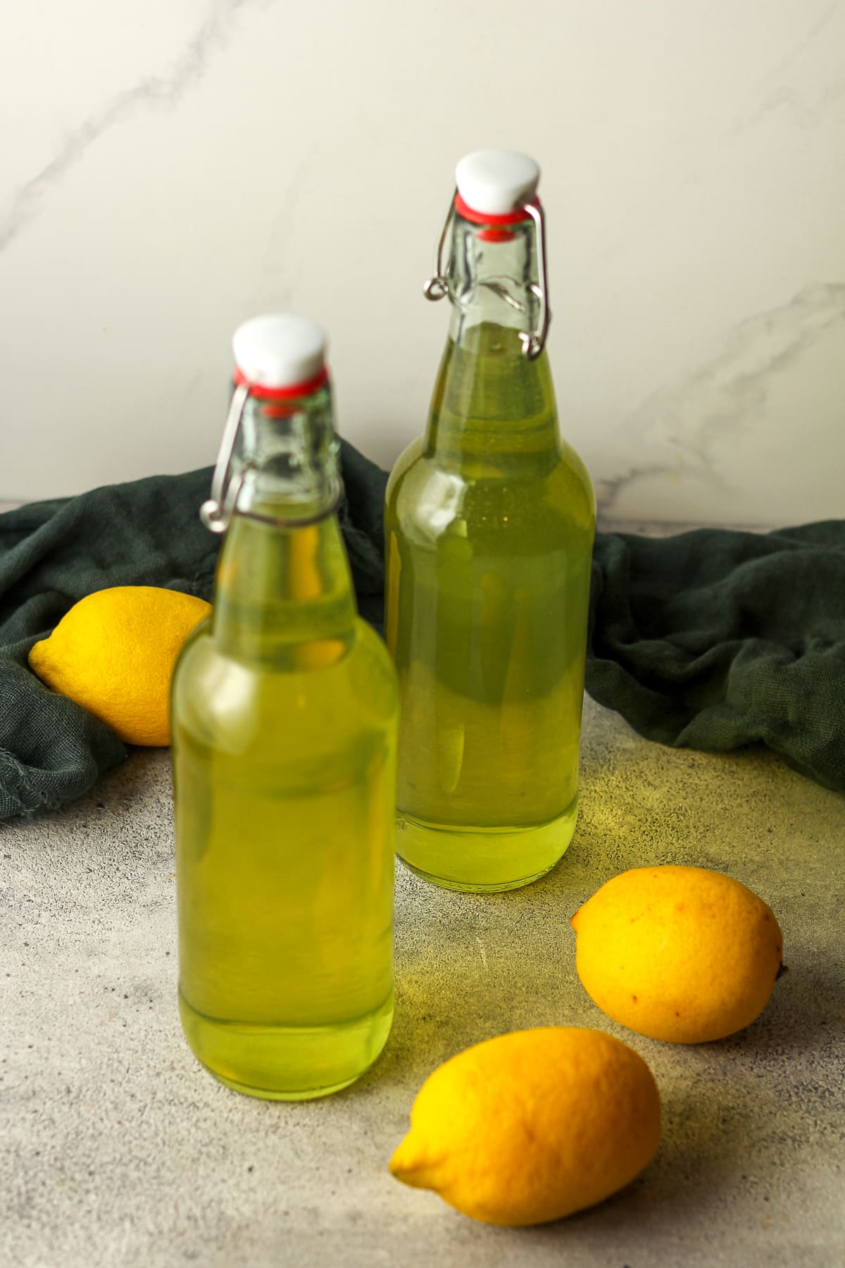 Side view of two skinny bottles of homemade limoncello.