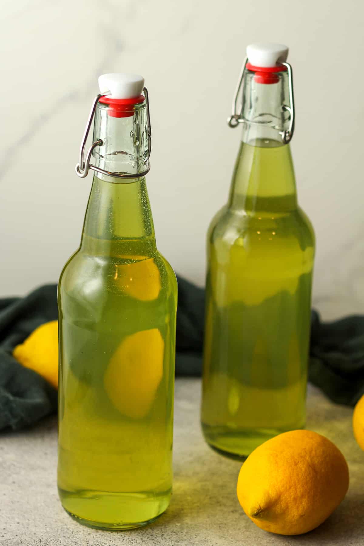 Side view of two bottles of homemade limoncello.