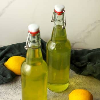 Side view of two bottles of homemade limoncello.