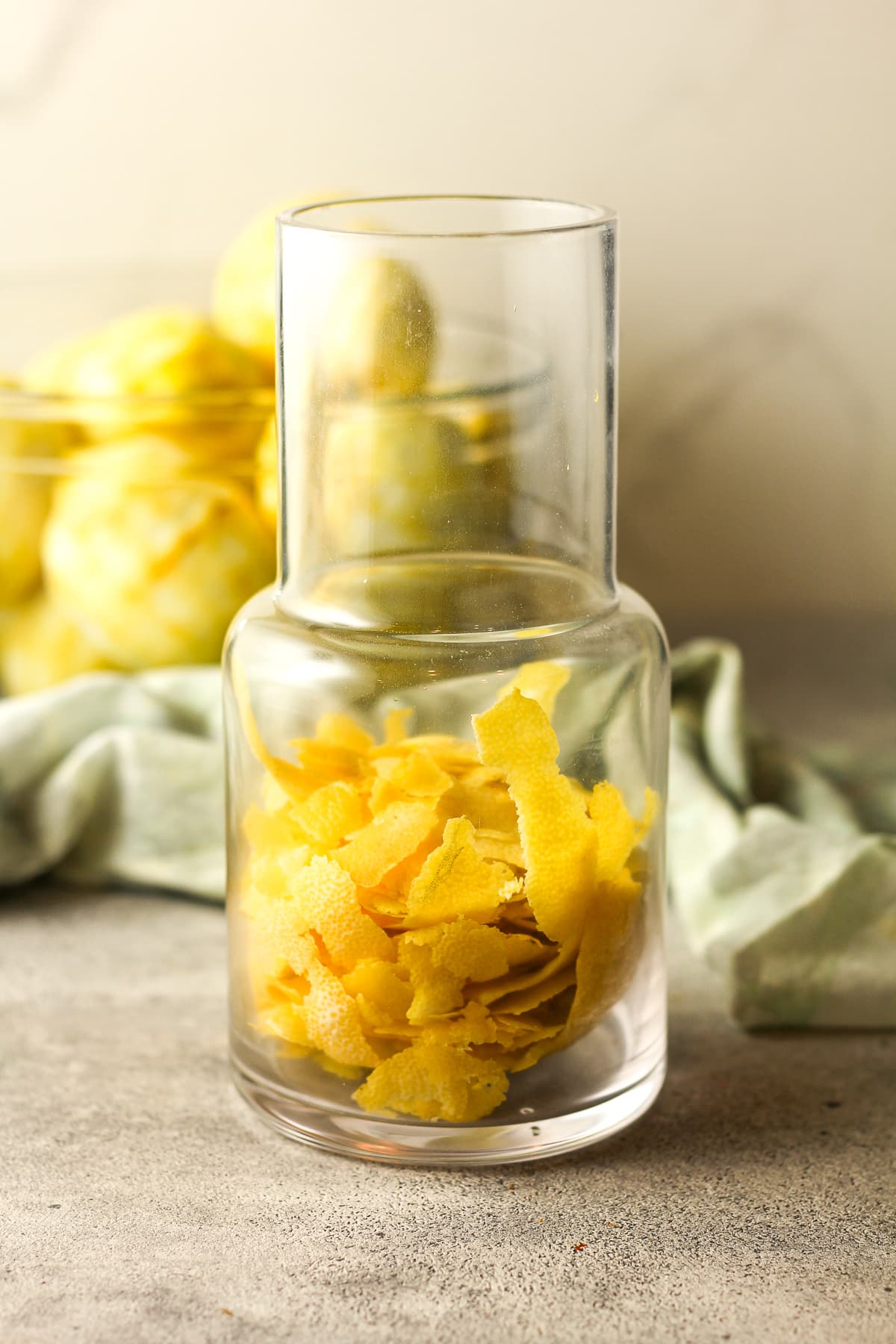 Side view of a carafe with lemon peels.