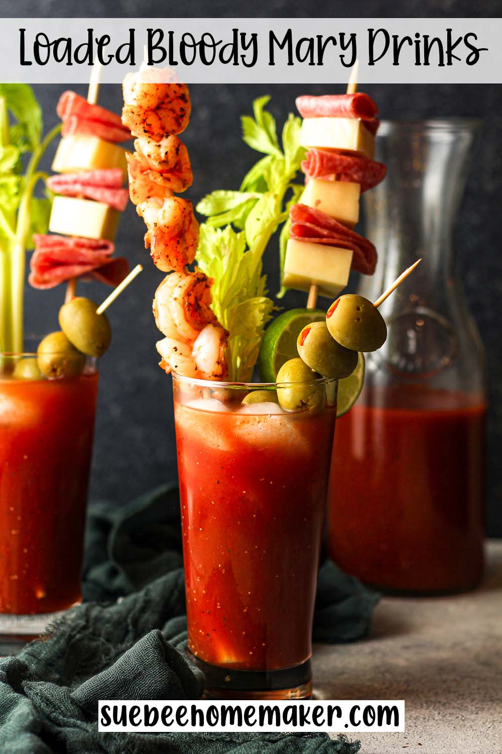 Side view of two loaded Bloody Mary drinks with garnishes.