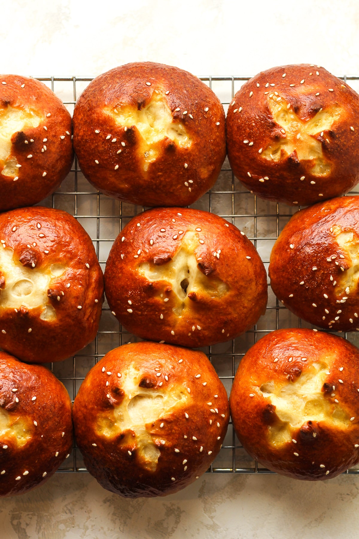 A wire rack with pretzel buns cooling.