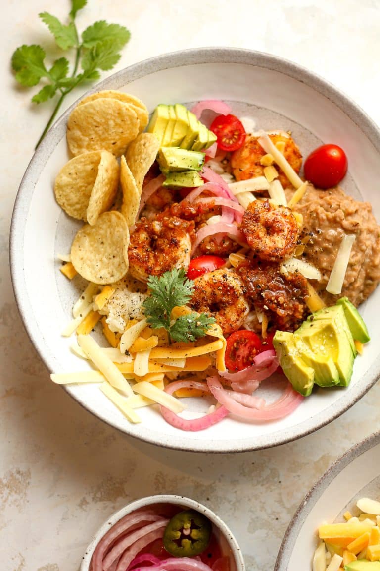 A shallow bowl of shrimp taco bowl with toppings.