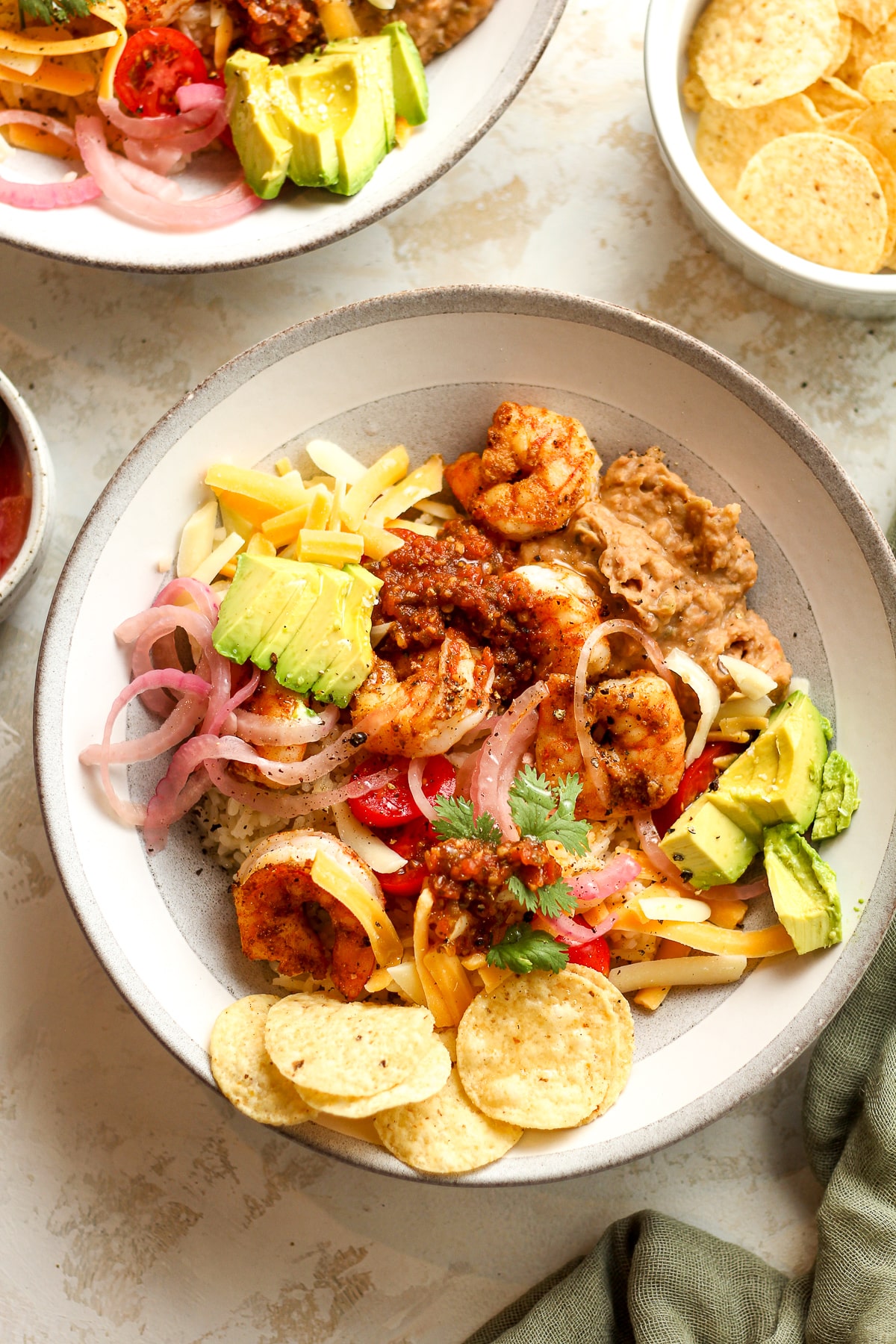 Two bowls of shrimp taco bowls with avocado.