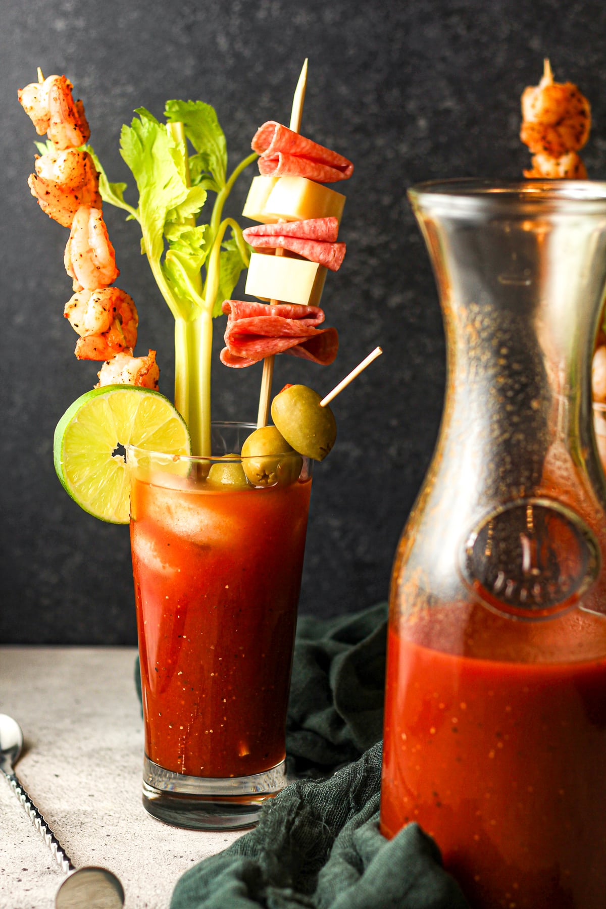 Side view of a spicy Bloody Mary drink with garnishes.