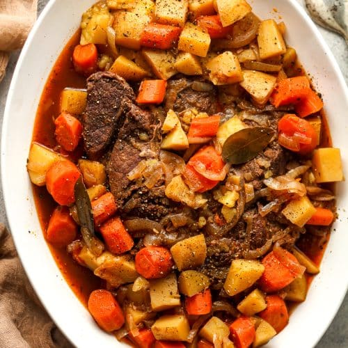 An oblong platter of the just cooked pot roast and veggies.