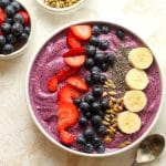 Closeup on a blueberry smoothie bowl with fruit and nuts.